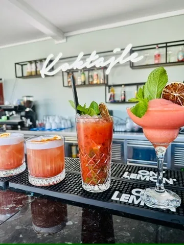Trzy koktajle pod neonem Koktajle — bordowe sour'y na bar macie
