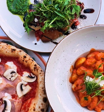 Trzy talerze BoMorze z góry — pizza Capriciosa, gnocchi al pomodoro, sałatka burrata