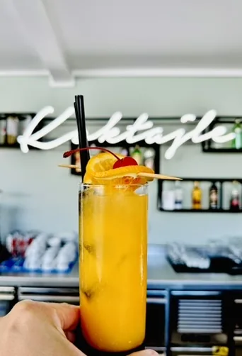Koktajl pomarańczowy w wysokiej szklance — neon Koktajle w tle