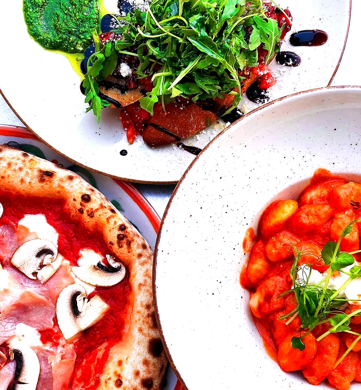 Gnocchi w sosie pomidorowym z burratą — obok pizza Capriciosa i bruschetta