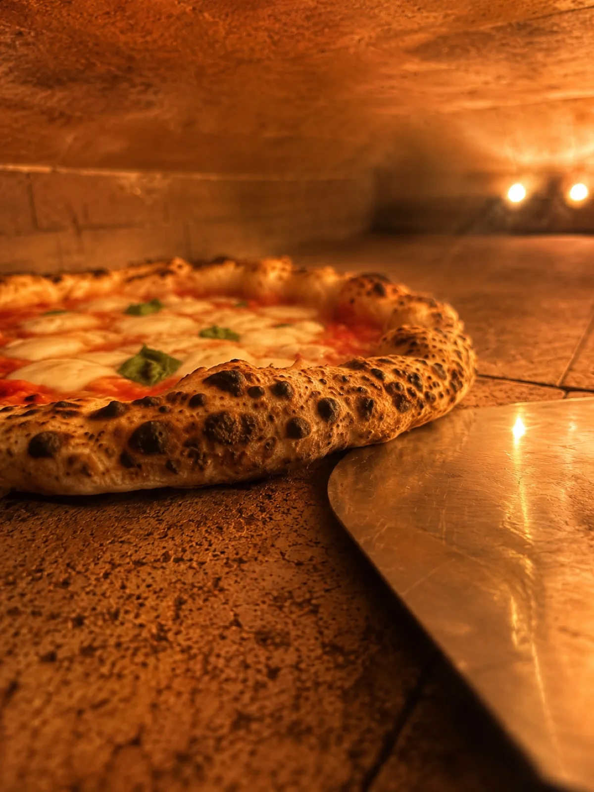 Pizza Margherita w piecu BoMorze — cornicione w bąble (leoparding), płomienie grzejników po prawej, podłoga szamotowa, podczas wypieku w 430°C